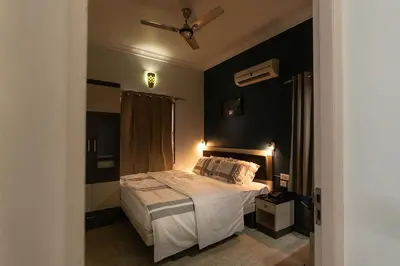 a bedroom with a bed and a ceiling fan at Hive Service Apartment in Coimbatore