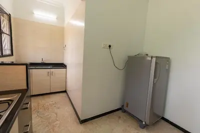 a kitchen with a refrigerator and a sink in it at Hive Service Apartment in Coimbatore