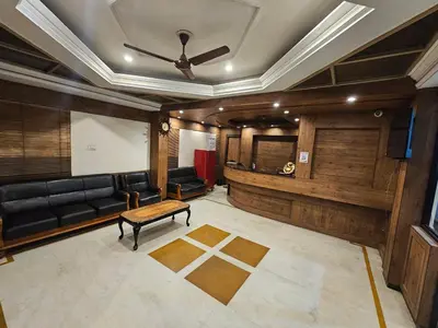a living room with a couch and a table at HOTEL MERILIN in Erode