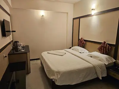 a hotel room with a bed and a large mirror at HOTEL MERILIN in Erode