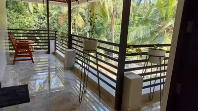 a balcony of a house with a view of trees at Aptha Ayurveda in Kadikkād