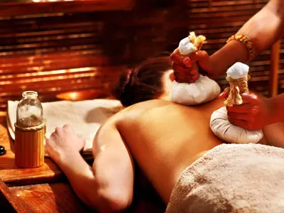 a naked woman laying on a bed with some food at Aptha Ayurveda in Kadikkād