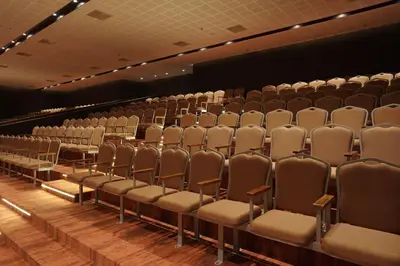 an empty auditorium with chairs and a screen at Gokulam Park Guruvayur in Guruvāyūr