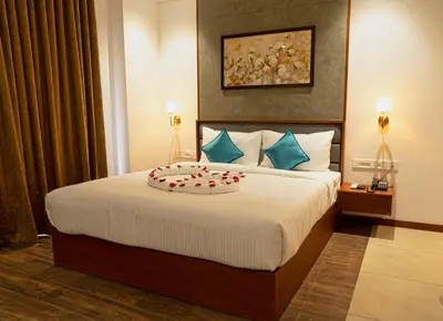 a hotel room with a bed with a cake on it at Gokulam Park Guruvayur in Guruvāyūr