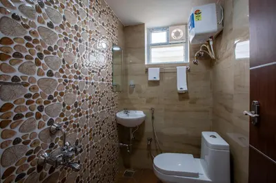 a bathroom with a toilet and a sink at MUGUNDAN 'S SMART STAY in Coimbatore