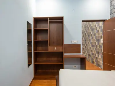 a room with wooden shelves and a bed at MUGUNDAN 'S SMART STAY in Coimbatore