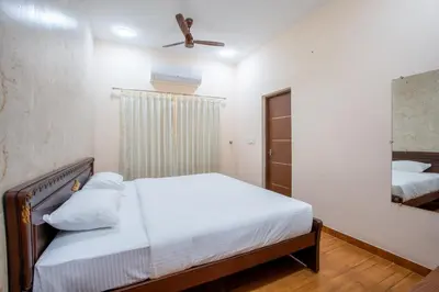 a bedroom with a bed and a mirror at MUGUNDAN 'S SMART STAY in Coimbatore