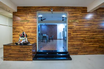 a lobby with a wooden wall with a mirror at MUGUNDAN 'S SMART STAY in Coimbatore