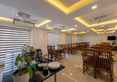 a dining room with tables and chairs in a restaurant at Airport Avenue Plaza in Nedumbassery
