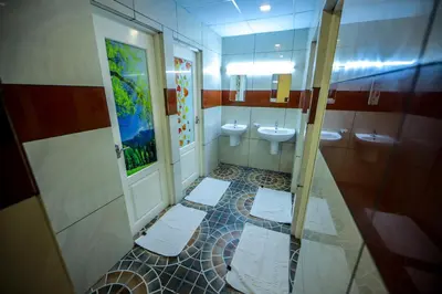 a bathroom with two sinks and two toilets at Airport Avenue Plaza in Nedumbassery