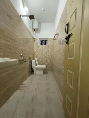 a bathroom with a toilet and a sink and a door at Kokaris Coorg Homestay in Kushālnagar
