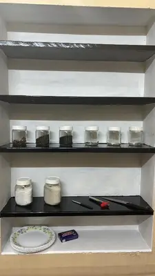 a shelf in a kitchen with jars and a plate at Kokaris Coorg Homestay in Kushālnagar