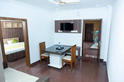 a room with a table and chairs and a bed at Hamsted in Kottakkal
