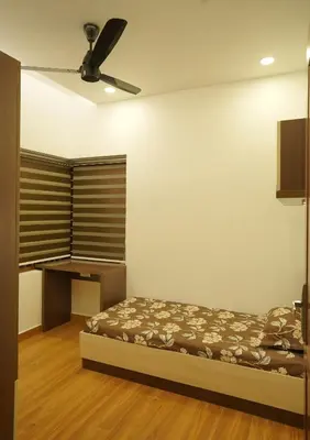 a bedroom with a bed and a ceiling fan at Homestay- Near to Cochin Airport in Kāladi