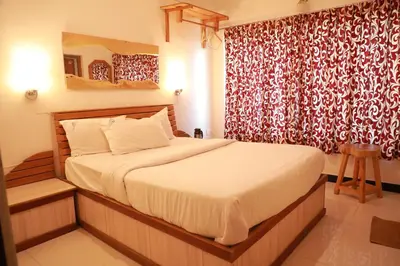 a bedroom with a bed and a red curtain at The Woodlands Residency- Unmarried and stag groups not allowed in Ooty