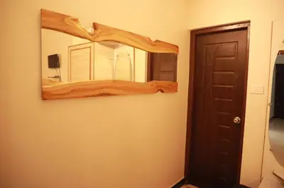 a mirror hanging on a wall in a room at The Woodlands Residency- Unmarried and stag groups not allowed in Ooty