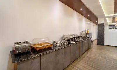 a kitchen with a counter with many pots and pans at Treebo Skydale Premium Suites, 1500 Mtrs From Ooty Lake in Ooty