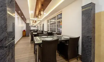 a dining room with a table and chairs at Treebo Skydale Premium Suites, 1500 Mtrs From Ooty Lake in Ooty