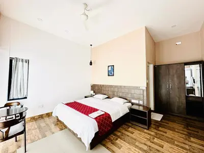 a bedroom with a large bed with a red blanket at Western Ghats Holiday Home in Kalpetta