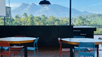 two tables and chairs with a view of a mountain at Western Ghats Holiday Home in Kalpetta
