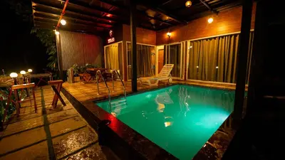 a small swimming pool in a backyard at night at Vayalada View Point Resort in Kozhikode