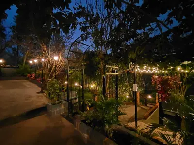 a garden lit up at night with lights at Pear Tree Entire 2BHK Villa Kotagiri in Kotagiri