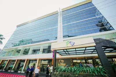 a large building with people standing outside of it at Hotel Bluebell in Kozhikode