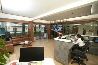 a man sitting at a desk in an office at Hotel Bluebell in Kozhikode