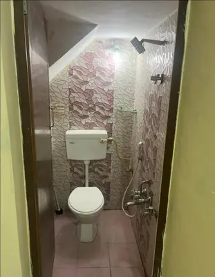 a small bathroom with a toilet and a shower at The bluebird residence in Mysore