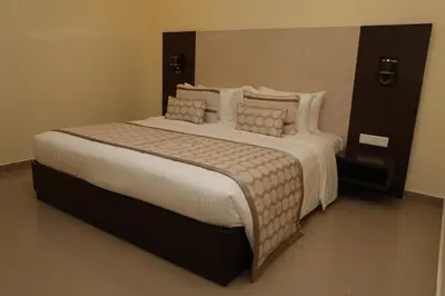a bedroom with a large bed with pillows at HOTEL SR in Palani