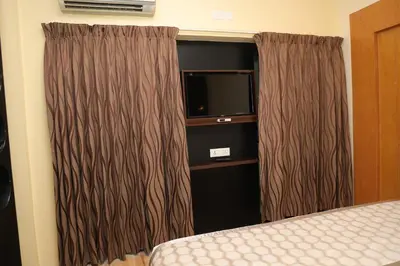 a hotel room with a bed and a television at HOTEL SR in Palani