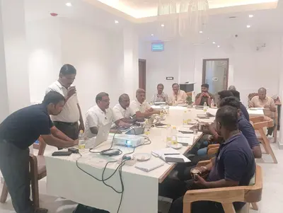a group of men sitting around a table in a room at HOTEL SR in Palani