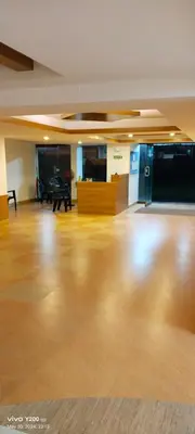 an empty room with a wooden floor and a piano at Platinum Airport Lounge by VVP in Nedumbassery
