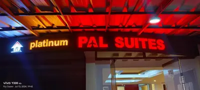 a neon sign for apal suites in a building at Platinum Airport Lounge by VVP in Nedumbassery