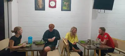 a group of people sitting at tables in a restaurant at Arasu Homestay in Antarasante