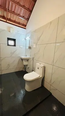 a bathroom with a toilet and a sink at Aadhya Homestay 4BHK in Wayanad