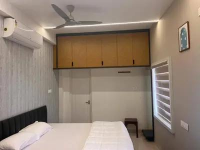 a bedroom with a white bed and a ceiling at Thulasi Avenue Inn in Pollāchi