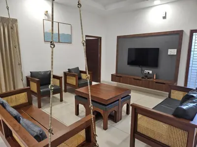 a living room with a swing and a tv at Thulasi Avenue Inn in Pollāchi