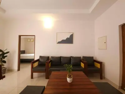 a living room with a couch and a table at Thulasi Avenue Inn in Pollāchi