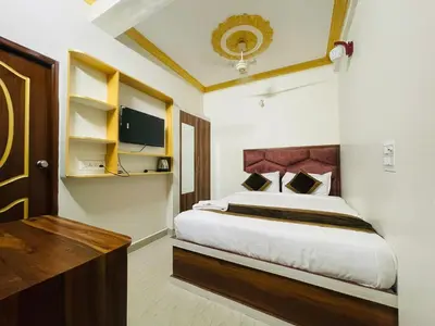a bedroom with a large bed with a wooden headboard at Hotel Boss Palace in Mysore