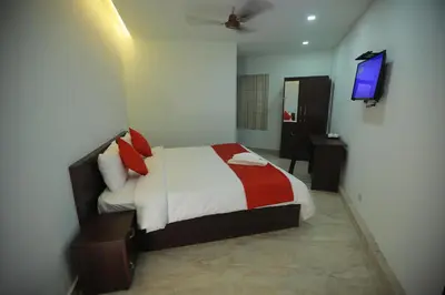a bedroom with a bed and a television in it at Premier Tourist Home in Kunnamkulam