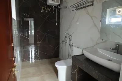 a bathroom with a sink and a shower and a toilet at Pear Tree Luxe Entire 3BHK Villa - Only For Family in Kotagiri