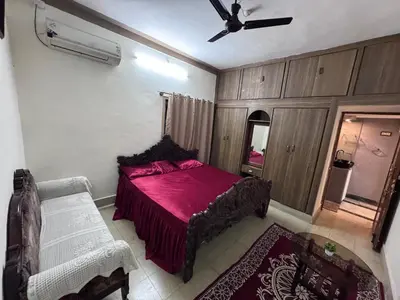 a bedroom with a red bed and a ceiling fan at NAS VILLA in Mysore