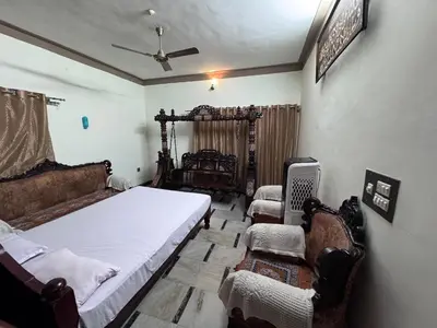 a bedroom with two beds and two chairs in it at NAS VILLA in Mysore