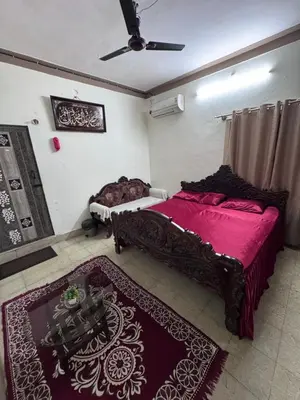 a bedroom with two beds with red sheets and a rug at NAS VILLA in Mysore