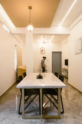 a table in a room with a person in the background at Avalon Homes in Perintalmanna