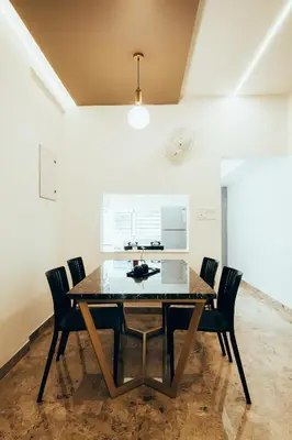 a dining room with a wooden table and chairs at Avalon Homes in Perintalmanna