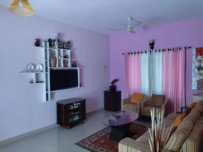 a living room with a couch and a tv at COZY Homes in Nedumbassery