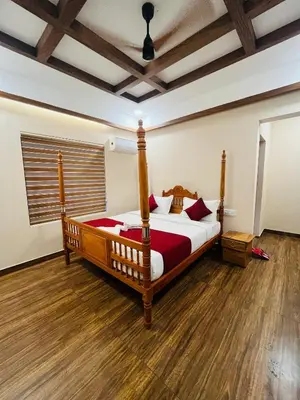 a bedroom with a large bed in a room at ATHIRAPPILY SREENILAYAM HERITAGE RESORt in Athirappilly