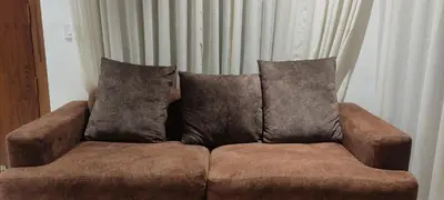a brown couch with two pillows on top of it at Mountain View Villa in Mukkam